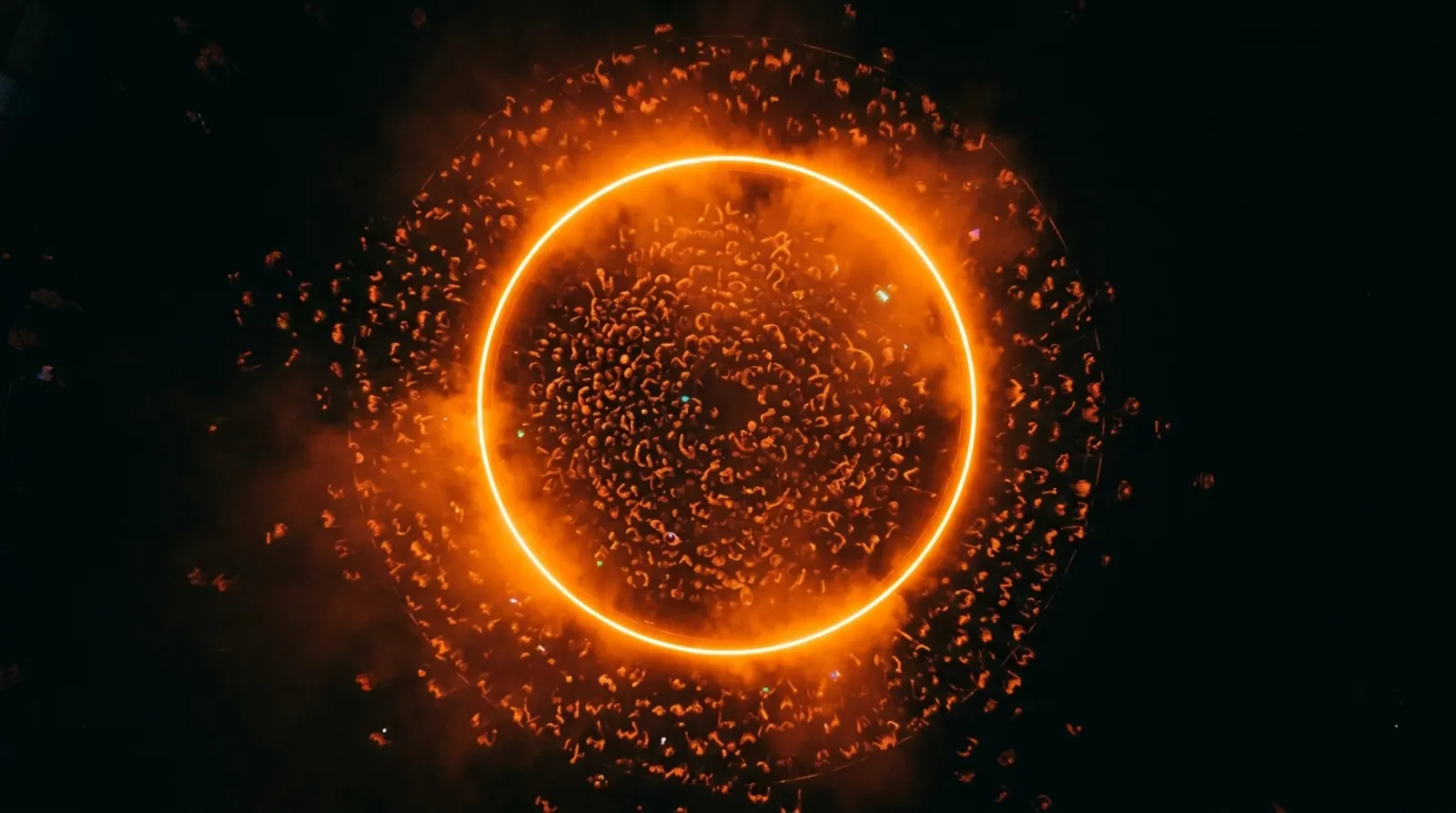 An orange ring surrounded by sparks, seen from above.