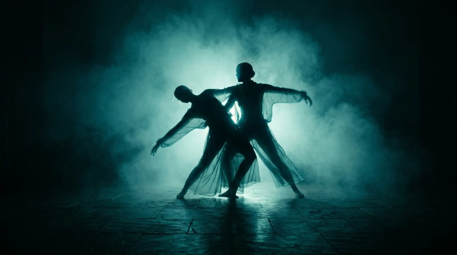 Two dancers backlit in turquoise amid smoke.